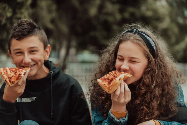 a boy and a girl on a lunch break at school. A meal in front of the school during a coronavirus pandemic. New normal. Selective focus. High quality photo