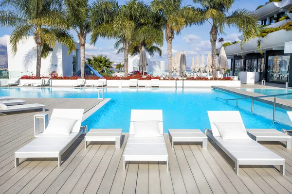 Swimming pool area with  white sun beds at the modern resort. — Stock Photo, Image