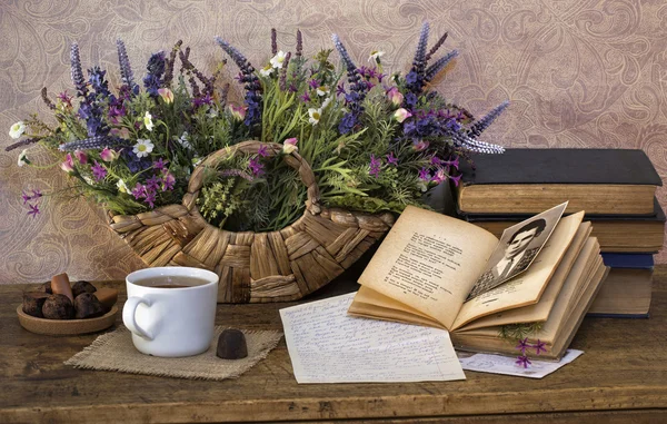 Eski kitaplar, parlak kurutulmuş çiçekli natürmort cam bardak tutucu ve trüf çikolata