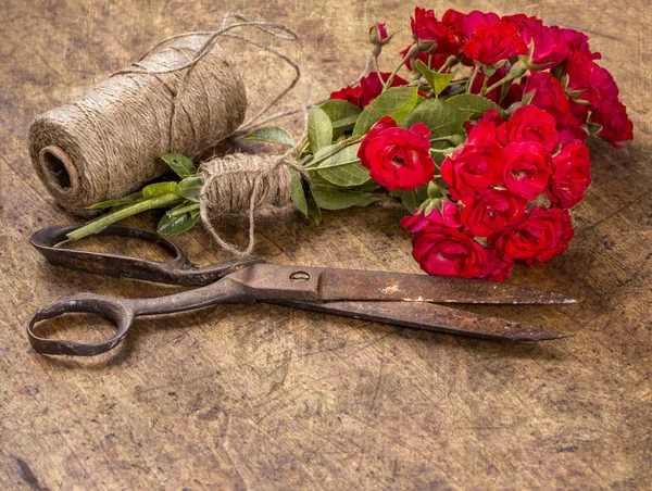 Buquê de rosas vermelhas, bola de fio e tesoura enferrujada velha em Wo — Fotografia de Stock