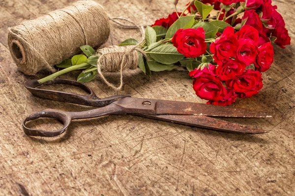 Buquê de rosas vermelhas, bola de fio e tesoura enferrujada velha em Wo — Fotografia de Stock