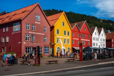 BERGEN, NORway - 25 Temmuz 2019: Norveç 'teki Bergen' de hansaetik ahşap evlerle eski kasaba merkezinde yürüyen insanlar. UNESCO Dünya Mirası.