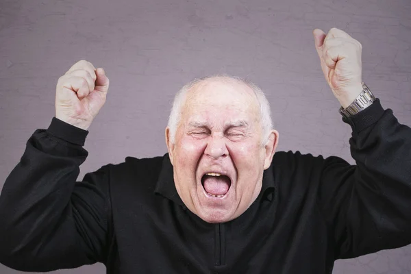 Un anciano muy emocional grita de dolor sobre un fondo gris . —  Fotos de Stock