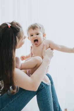 Güzel anne portre sevimli küçük kızı bir beyaz odada ile sabah oynarken