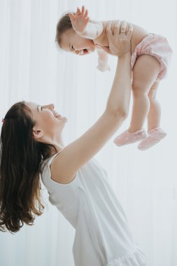 Güzel anne portre sevimli küçük kızı bir beyaz odada ile sabah oynarken