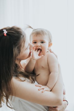 Güzel anne portre sevimli küçük kızı bir beyaz odada ile sabah oynarken