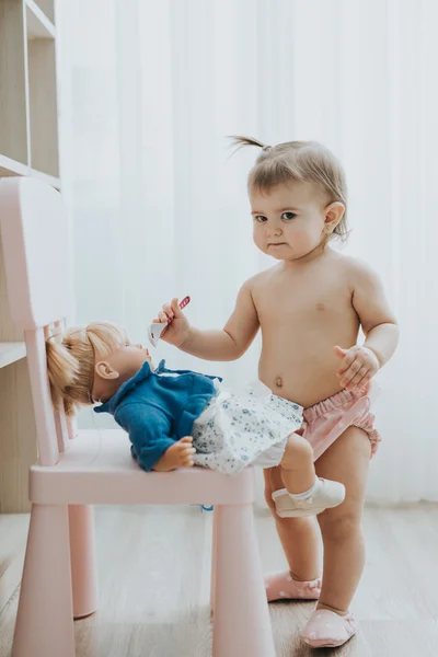 Linda niña jugando en una habitación blanca por la mañana con juguetes —  Fotos de Stock