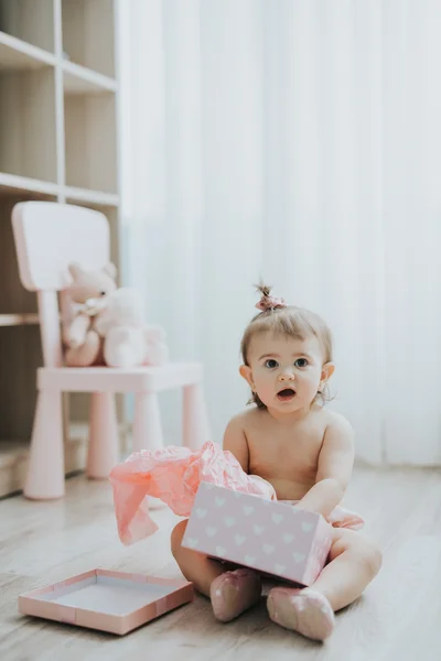 Милая девочка, играющая утром в белой комнате с игрушками — стоковое фото