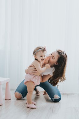 Güzel anne portre sevimli küçük kızı bir beyaz odada ile sabah oynarken