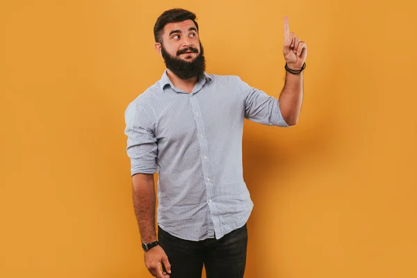 Retrato de bonito sorridente homem isolado no amarelo estúdio de fundo posando para a câmera e fazendo caras engraçadas tem uma ideia — Fotografia de Stock