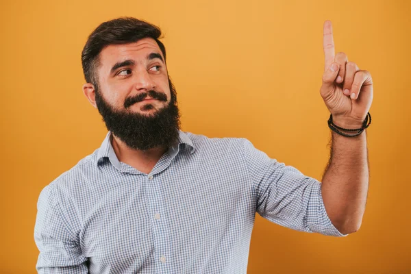 Retrato de bonito sorridente homem isolado no amarelo estúdio de fundo posando para a câmera e fazendo caras engraçadas tem uma ideia — Fotografia de Stock