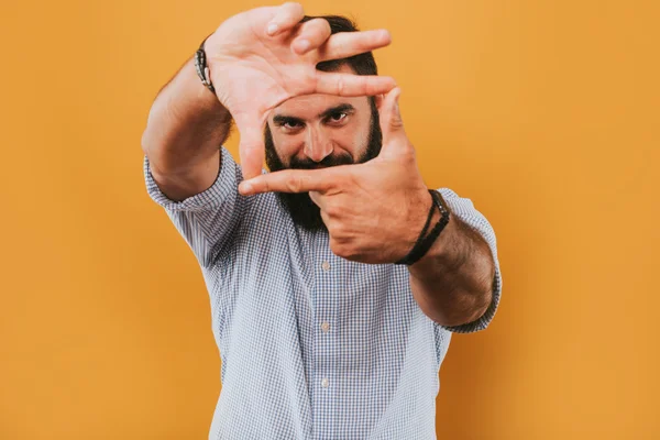 Retrato de belo homem sorridente isolado no estúdio amarelo posando para a câmera e fazendo rostos engraçados selfie — Fotografia de Stock