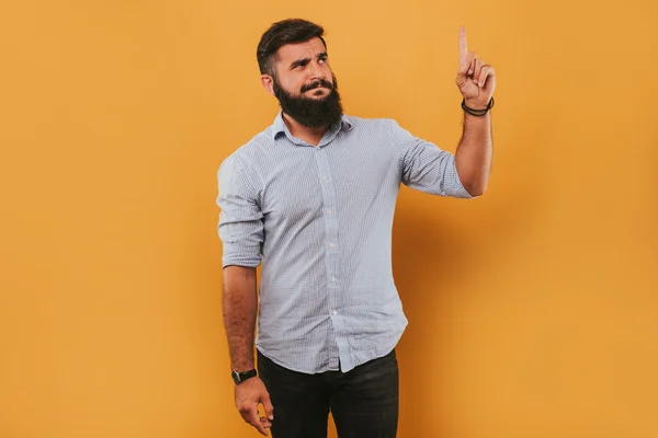 Retrato de bonito sorridente homem isolado no amarelo estúdio de fundo posando para a câmera e fazendo caras engraçadas tem uma ideia — Fotografia de Stock