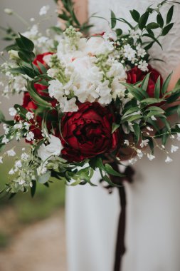 Sunset bulvarında orman ellerinde çiçeklerle beyaz hippi tarzı elbiseyle poz bir düğün gelin portresi