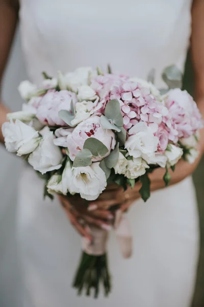 夕日の森で手に花を持つ白いヒップ スタイル ドレスでポーズをとって結婚式の花嫁の肖像画 — ストック写真