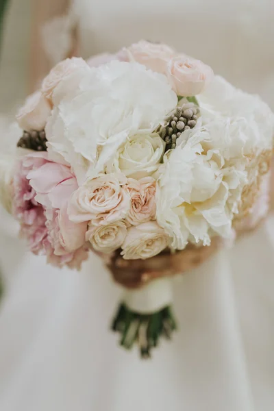 Ritratto di una sposa nuziale in posa in un abito bianco stile hipster con fiori tra le mani nella foresta al tramonto — Foto Stock