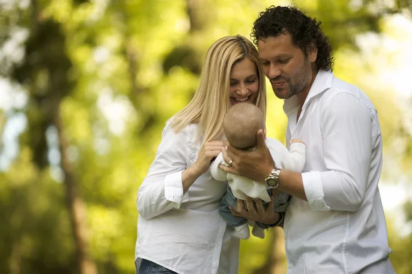 Happy parents having good time with their little boy in green park — Stock Photo, Image