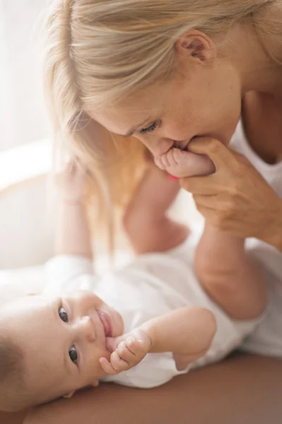 Bela mãe retrato brincando com seu menino bonito no sofá — Fotografia de Stock