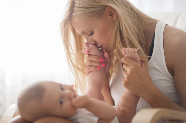 Bela mãe retrato brincando com seu menino bonito no sofá — Fotografia de Stock