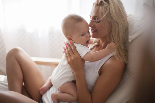 Bela mãe retrato brincando com seu menino bonito no sofá — Fotografia de Stock