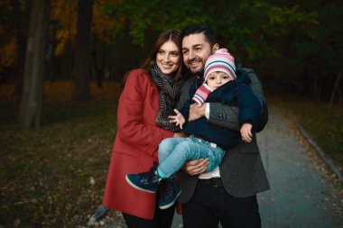 Gülümseyen çift ile onların sevgili bebek kız parkta oynarken