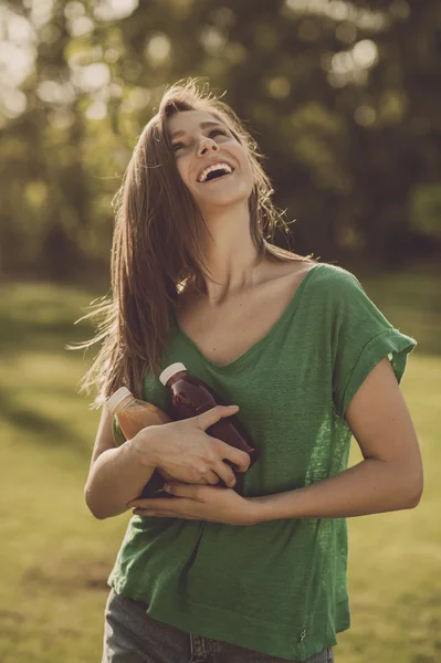 Винтажный портрет красивой улыбающейся девушки с бутылками детоксикационного сока в руках — стоковое фото