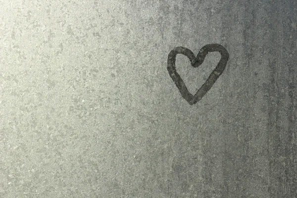 Coração em vidro congelado. Gelo no fundo de uma janela. Pequeno Fotografia De Stock