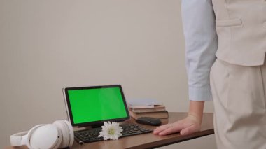 İdari Profesyoneller Günü 'nden dolayı tebrik alan mutlu bayan çalışanımız, ofisinin klavyesine kibarca bir papatya, yakınındaki yeşil ekran tabletine de bir papatya ekliyor. Yüksek kalite 4k görüntü