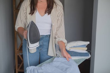 Giysileri ütülemek ve buharlaştırmak ev bakımının bir parçası olarak gardırobundaki temizliği ve güvenliği sağlamak için.