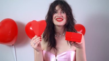Mutlu kız sevgilisinden bir Sevgililer Günü hediyesi alıyor, neşe ve heyecanla gülümsüyor. Yüksek kalite 4k görüntü