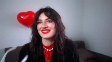 Sevgililer Günü partisine hazırlanmak, kalp şeklinde gözlük takmak ve odayı balonlarla süslemek..