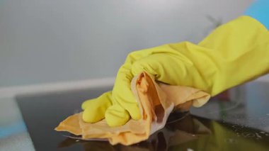 Bir kadın mutfaktaki elektrikli sobayı yeşil bir temizlik için çevre dostu temizlik bezleri kullanarak temizliyor. Yüksek kalite 4k görüntü