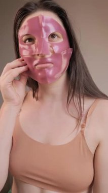 Kadın yüzüne soğutulmuş hidrojel maske takarak cildine canlandırıcı ve besleyici bir his veriyor. Yüksek kalite 4k görüntü