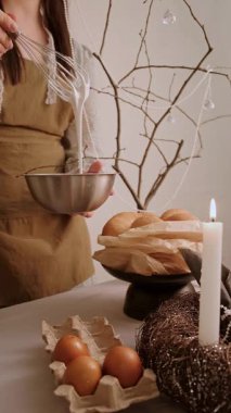 Paskalya bayramında önlüklü kadın güzel bir şekilde hazırlanmış şenlik masasında pasta için jöle yapıyor. Yüksek kalite 4k görüntü