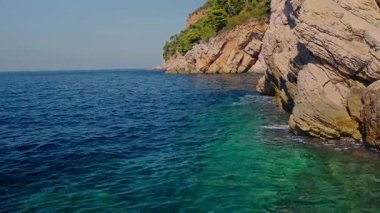 Petrovac Riviera 'nın sarp kayalıklarıyla panoramik manzarası yeşil ağaçlar ve seyahat ve rahatlama için ideal turkuaz su. Yüksek kalite 4k görüntü