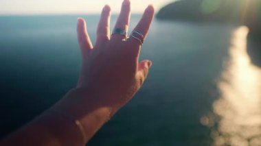 Arka planda sakin deniz manzarası olan büyük halkalar takan kadınların yakın çekimi. Yüksek kalite 4k görüntü