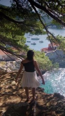 Uçsuz bucaksız etek giyen, Petrovac Riviera Karadağ 'ın yeşil dağları ve açık mavi Adriyatik Denizi manzarasının tadını çıkaran bir kız. Yüksek kalite 4k görüntü