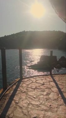 Budva, Karadağ 10 Eylül 2025 'te, turuncu kayalık gibi yeşil ağaçlar ve Budva' daki plajlar arasında insanların yürüdüğü dolambaçlı bir patika ile deniz kenarı. Yüksek kalite 4k görüntü