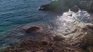 Dalgaların köpüklü su ve dramatik sıçramalar yarattığı devasa kaya parçalarıyla Adriyatik kıyılarının panoramik manzarası. Yüksek kalite 4k görüntü