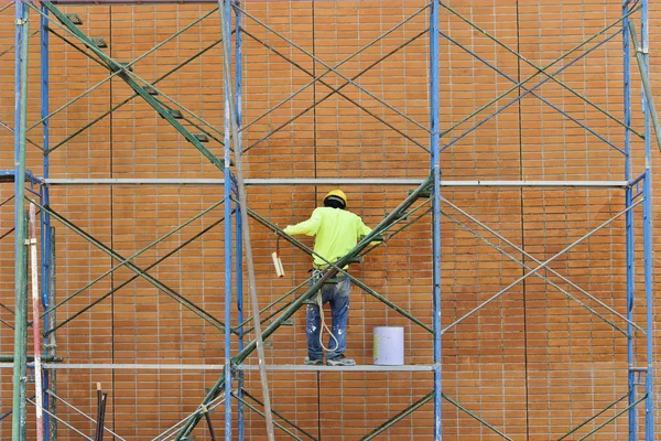 Man som arbetar på byggnadsställningar. — Stockfoto