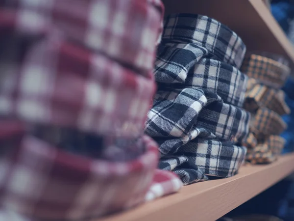 Plaid shirt on the shelf. Neatly folded clothes. The concept on — Stock Photo, Image