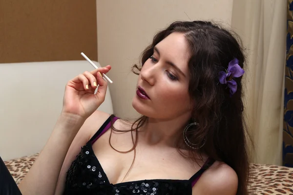 Jovem sexy menina luzes um cigarro em casa . — Fotografia de Stock