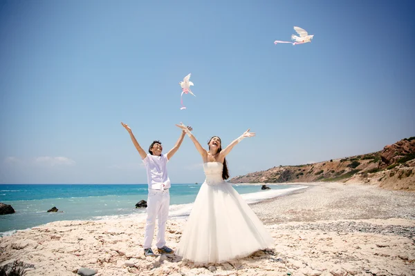 Mutlu gelin ve damat gülümseyen güneşli bir günde güvercinler beyaz serbest eller. Akdeniz. Kıbrıs