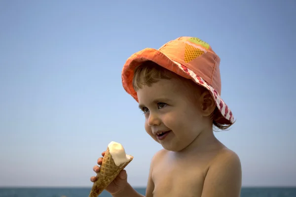 Niño pequeño comiendo helado en la playa — Foto de Stock