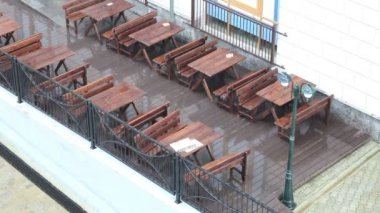 Boş kafe. şiddetli yağmur. Islak tablolar ve menü. Yukarıdan görüntüleyin. Sesli video.