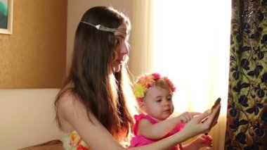 Kızı ruj dudakları annesiyle oluşturur. Anne ile kızı pencerenin yakınında kreş çalış.