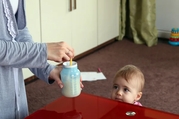 Matka, przygotowanie mleka dla dziecka. dziecko w tle. poziome — Zdjęcie stockowe