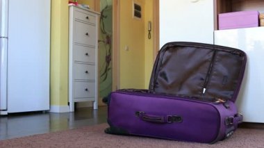 küçük çocuk Giysi, top, balon ve oyuncaklar çantaya koyar