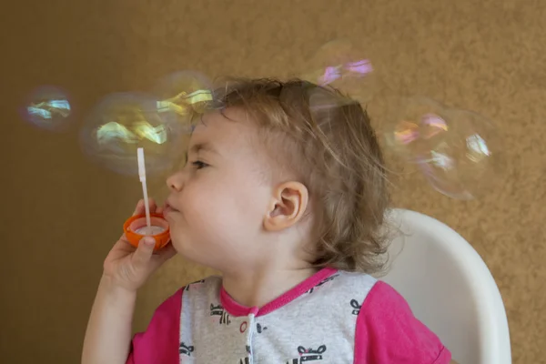 Clouse-up retrato de dos años chica infla una burbuja circular — Foto de Stock