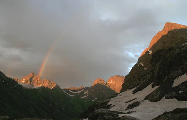 Kleurrijke regenboog in de berg na regen en stormachtige wolken — Stockfoto